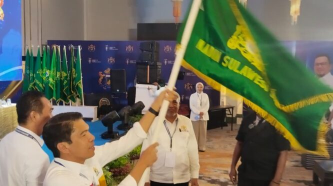 Gufran Ahmad mengangkat bendera Kadin setalah menang dalam pemilihan ketua umum Kadin Sulteng melakukan Musda provinsi